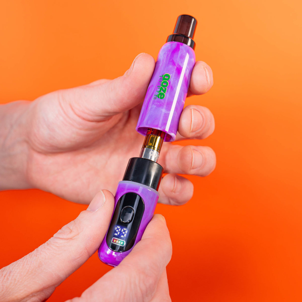 Purple Ooze Hivo Conceal vape pen with digital display held in a hand against an orange background