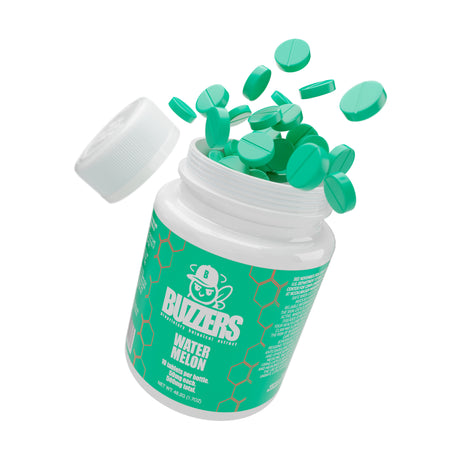 Open container of Buzzers watermelon-flavored cat's claw extract tablets with scattered tablets on a white background.