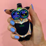 Close up of a hand holding the glitch Ooze Hoot Owl character vape battery against a light pink background
